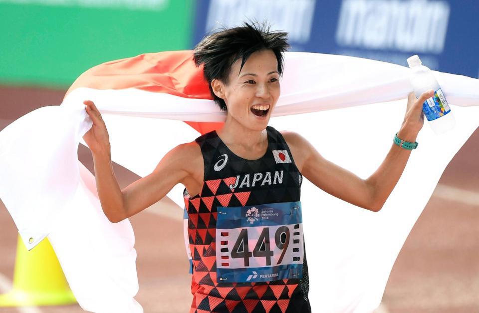 女子マラソンで２位となり、日の丸を広げて喜ぶ野上恵子＝ジャカルタ（共同）