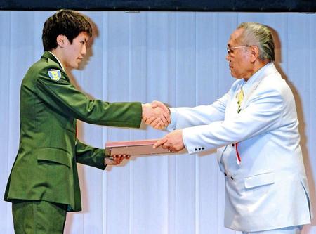 ２０１３年の年間表彰式で、山根明会長（右）と握手を交わす成松大介