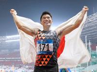 男子２００メートルで優勝し、笑顔で日の丸を広げる小池祐貴＝ジャカルタ（共同）