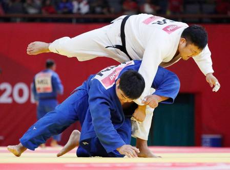 　準決勝で韓国・金成民（上）と対戦する王子谷剛志。関節を取ったとして反則負けとなった＝ジャカルタ（共同）