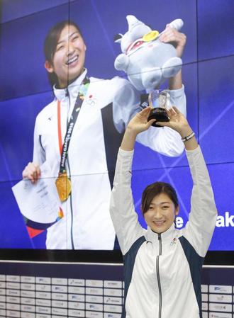 　ジャカルタ・アジア大会のＭＶＰに選ばれ、笑顔でトロフィーを掲げる競泳の池江璃花子。日本選手の１大会最多となる６冠を達成した＝２日、ジャカルタ（共同）