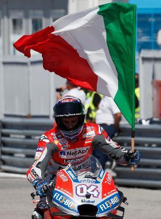 　世界選手権シリーズ第１３戦、サンマリノＧＰを制し、地元イタリアの国旗を掲げるドゥカティのアンドレア・ドビツィオーゾ＝９日、ミサーノアドリアティコ（ＡＰ＝共同）