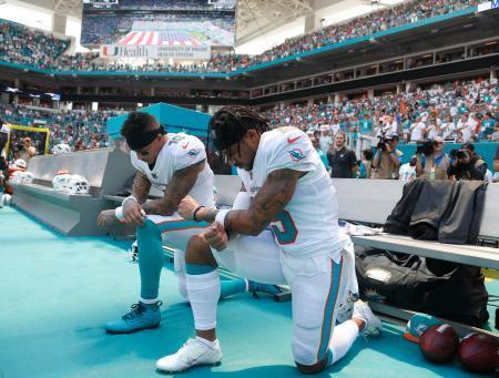 　ＮＦＬタイタンズ戦での国歌斉唱で、膝をついて人種差別に抗議の意を表すドルフィンズのＷＲスティルズ（左）とＷＲウィルソン＝９日マイアミガーデンズ（ＡＰ＝共同）