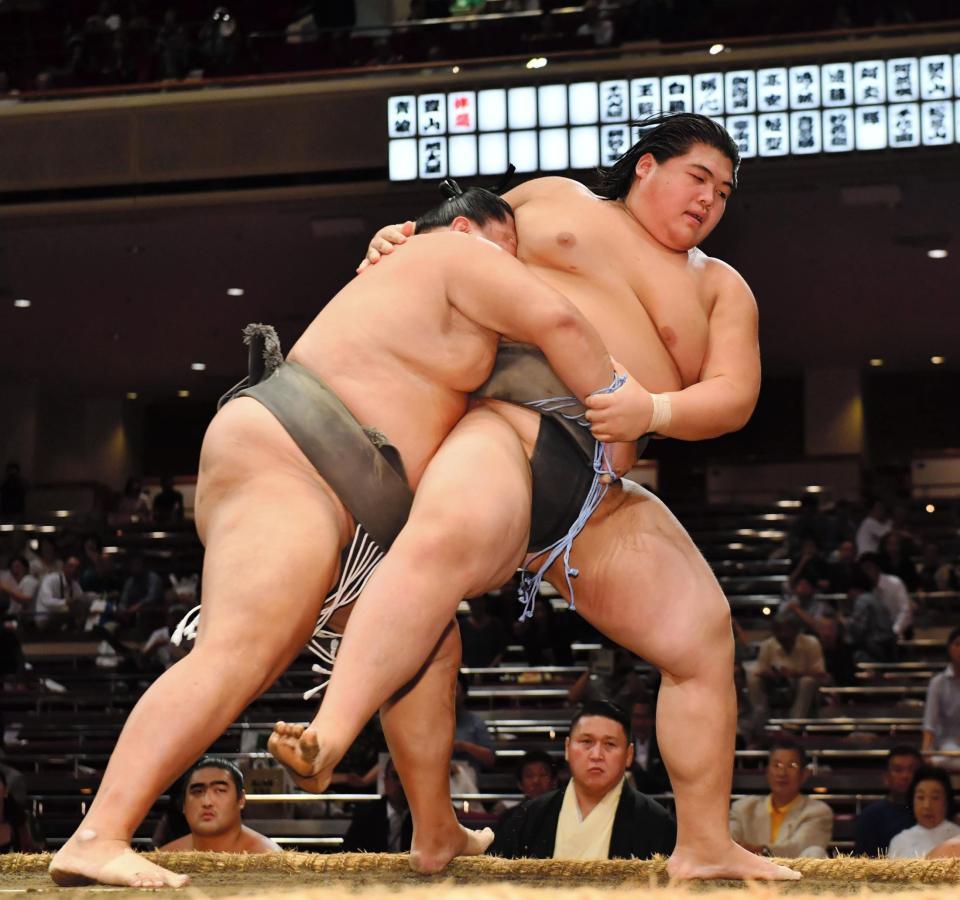 魁（左）に送り出しで敗れた納谷＝両国国技館（撮影・中田匡峻）