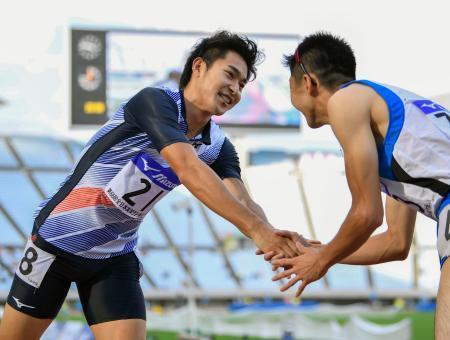 　男子２００メートルで優勝し笑顔の飯塚翔太（左）＝ヤンマースタジアム長居