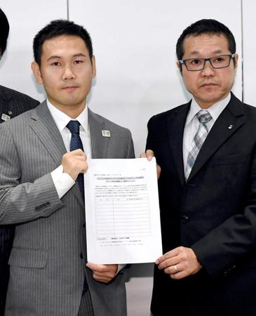 　日本ボクシング連盟の菊池浩吉副会長（右）とともに、東京五輪でのボクシング競技存続の署名用紙を持つボクシング元世界王者の高山勝成