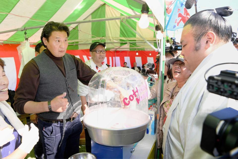 　「炭坑節まつり」の露店で綿菓子を作りながら、貴景勝（右）と話す花田光司氏