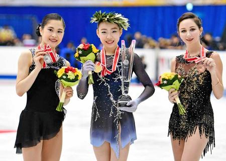 　優勝し笑顔を見せる紀平梨花（中央）。左は２位の宮原知子、右は３位のトゥクタミシェワ