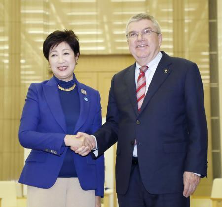 　握手するＩＯＣのバッハ会長（右）と東京都の小池百合子知事＝２５日午後、東京都庁