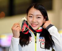 メダルを手に笑顔を見せる紀平梨花＝成田空港