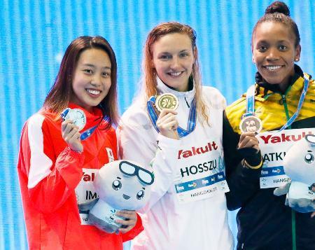 　女子１００メートル個人メドレーで２位となり、笑顔でメダルをかざす今井月（左）＝杭州（共同）
