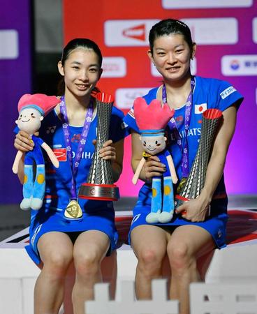 　女子ダブルスで優勝し、トロフィーを手に笑顔の高橋礼（右）、松友組（共同）