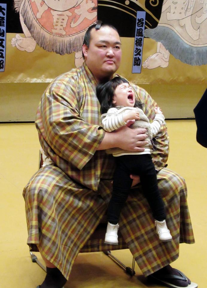 号泣する赤ちゃんを抱っこする稀勢の里