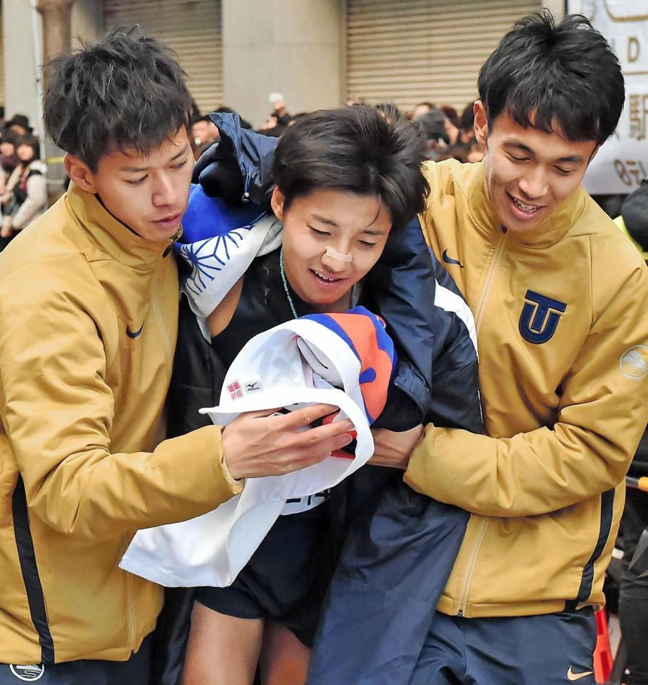 ３位でゴールし、チームメートに抱えられながら引き揚げる東洋大・大沢駿（中央）