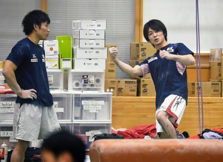 　公開された強化合宿で、ポーズを取りながら談笑する内村航平（右）＝東京都北区の味の素ナショナルトレーニングセンター