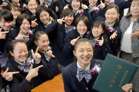 　卒業証書を手にクラスメートらと笑顔を見せるフィギュアスケート女子の坂本花織＝２１日、神戸市