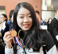 金メダルを手に笑顔の紀平梨花＝関西空港