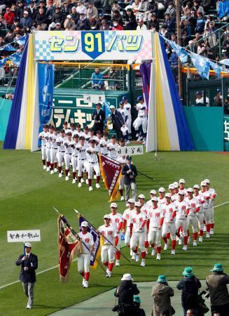 　第９１回選抜高校野球大会の開会式で入場行進する智弁和歌山（手前）と日章学園の選手ら＝２３日午前、甲子園球場