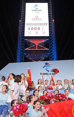 　「開幕まで１０００日」の文字が表示された２０２２年北京冬季五輪のカウントダウンのタイマーの前で盛り上がる若者ら＝１０日、北京（共同）