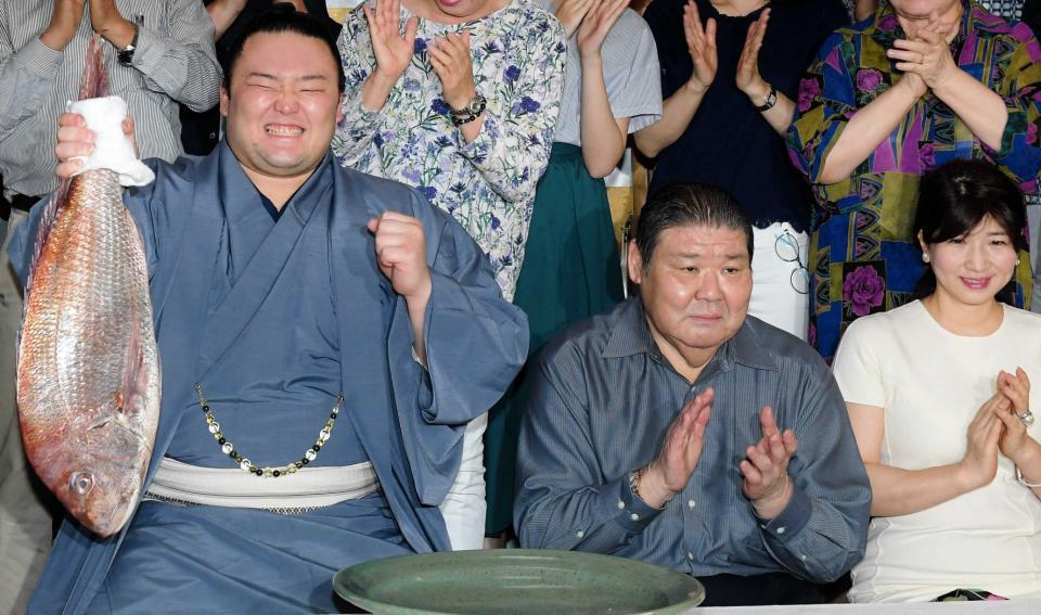 　初優勝で鯛を持ち、笑顔を見せる朝乃山