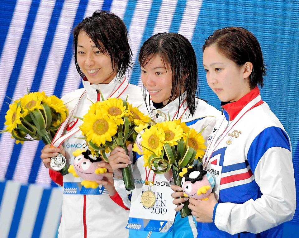 　女子１００ｍ平泳ぎで優勝した青木玲緒樹（中央）。左は２位の鈴木聡美、右は３位の渡部香生子（撮影・堀内翔）