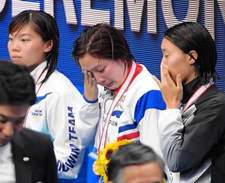 　女子２００ｍ平泳ぎで優勝するも派遣標準記録をクリアできず、表彰式で涙を流す渡部香生子（中央）