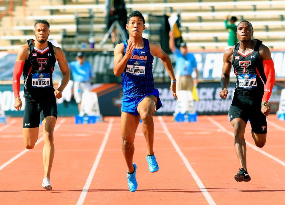 　男子１００メートル準決勝で、１着だったオドゥドゥル（右）と競り合うサニブラウン（中央）＝共同