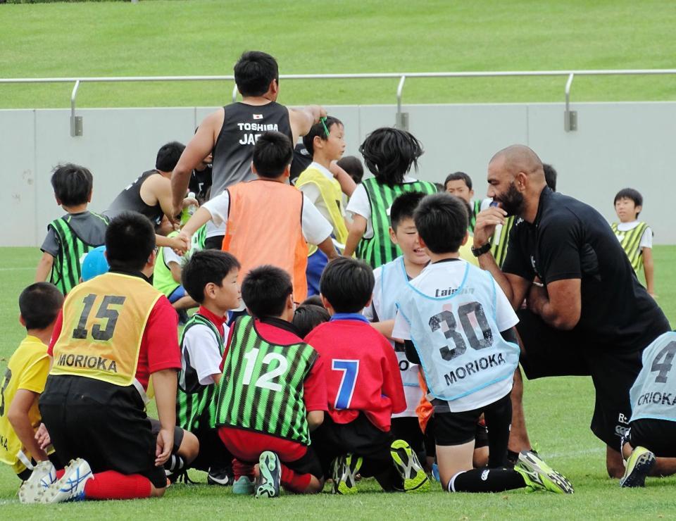ラグビー日本代表がラグビー教室を開催。子どもたちと輪になって話すリーチ・マイケル主将（右）