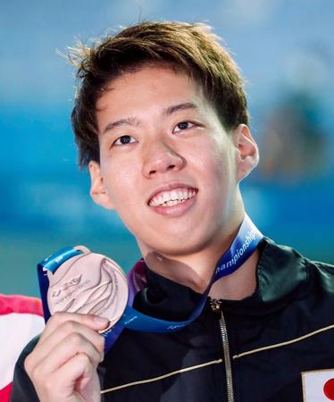 男子２００メートル平泳ぎで獲得した銅メダルを手に笑顔の渡辺一平＝光州（共同）