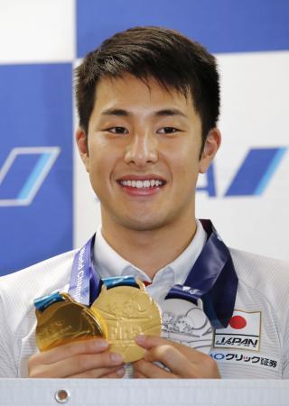 　世界水泳で獲得したメダルを手に笑顔の瀬戸大也＝２９日午後、羽田空港