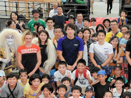 　会場に集まった子供たちと集合写真を撮影する（左から）カティンカ・ホッスー、大橋悠依、松元克央、瀬戸大也