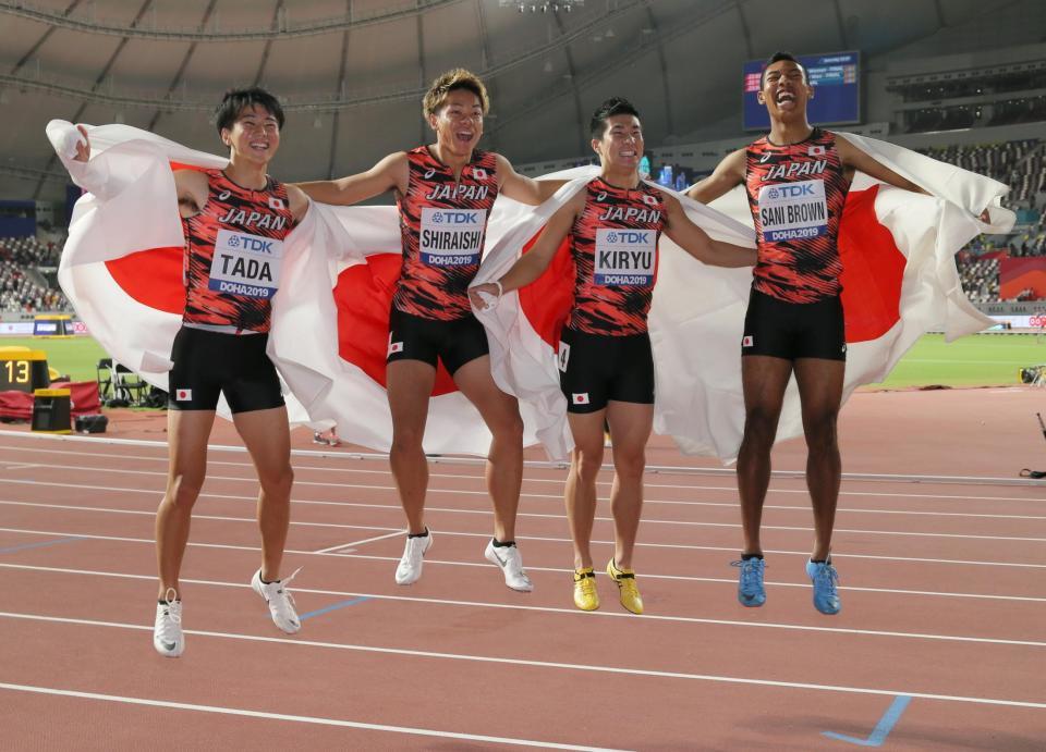 　男子４００メートルリレーで３位となり、日の丸を背にジャンプして喜ぶ（左から）多田、白石、桐生、サニブラウン