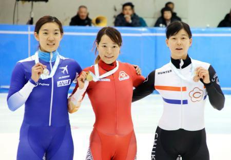 　女子５００メートルで優勝し、メダルを手にポーズをとる菊池純礼（中央）。左は２位の神長汐音＝帝産アイススケートトレーニングセンター