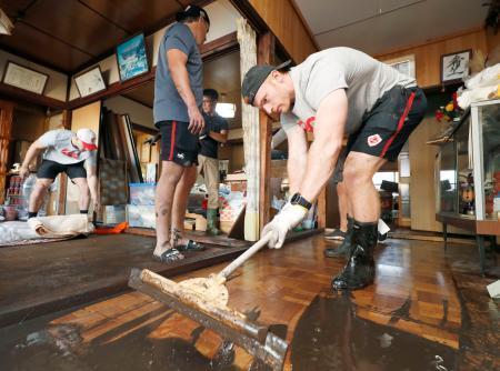 　床上浸水した住宅から泥をかき出すラグビーＷ杯カナダ代表のピーター・ネルソン＝１３日午後、岩手県釜石市