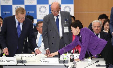 　４者協議の冒頭、ＩＯＣのコーツ調整委員長（左）に書類を手渡す東京都の小池百合子知事（代表撮影）
