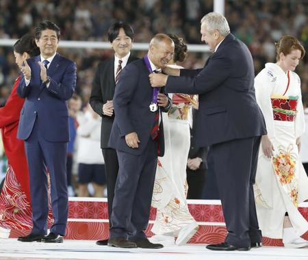 　ビル・ボーモント会長（右）から準優勝メダルを贈られるエディー・ジョーンズＨＣ。降壇後、メダルをポケットに入れた＝２日夜、横浜市の日産スタジアム