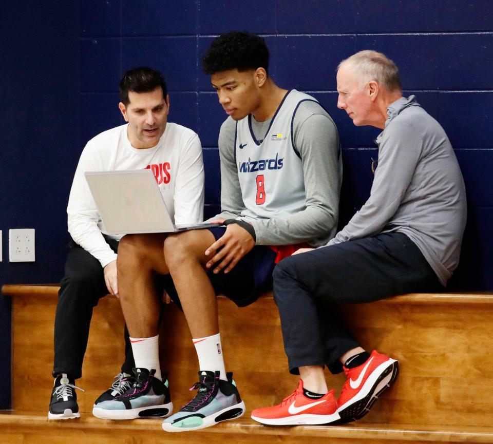 　コーチらとパソコンを見ながら話すウィザーズの八村（中央）＝共同