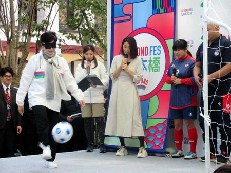 ブラインドサッカーを体験する小池百合子東京都知事（左）＝東京都中央区