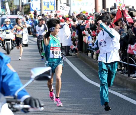 ４区、１５キロ地点で給水員と顔を見合わせてガッツポーズする青学大・吉田祐也（左）＝代表撮影