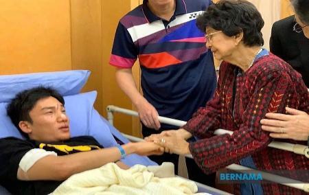 　事故で顔を負傷し、病院でマレーシア首相夫人から見舞いを受ける桃田賢斗選手（左）＝１３日、クアラルンプール近郊プトラジャヤ（ベルナマ通信提供・共同）