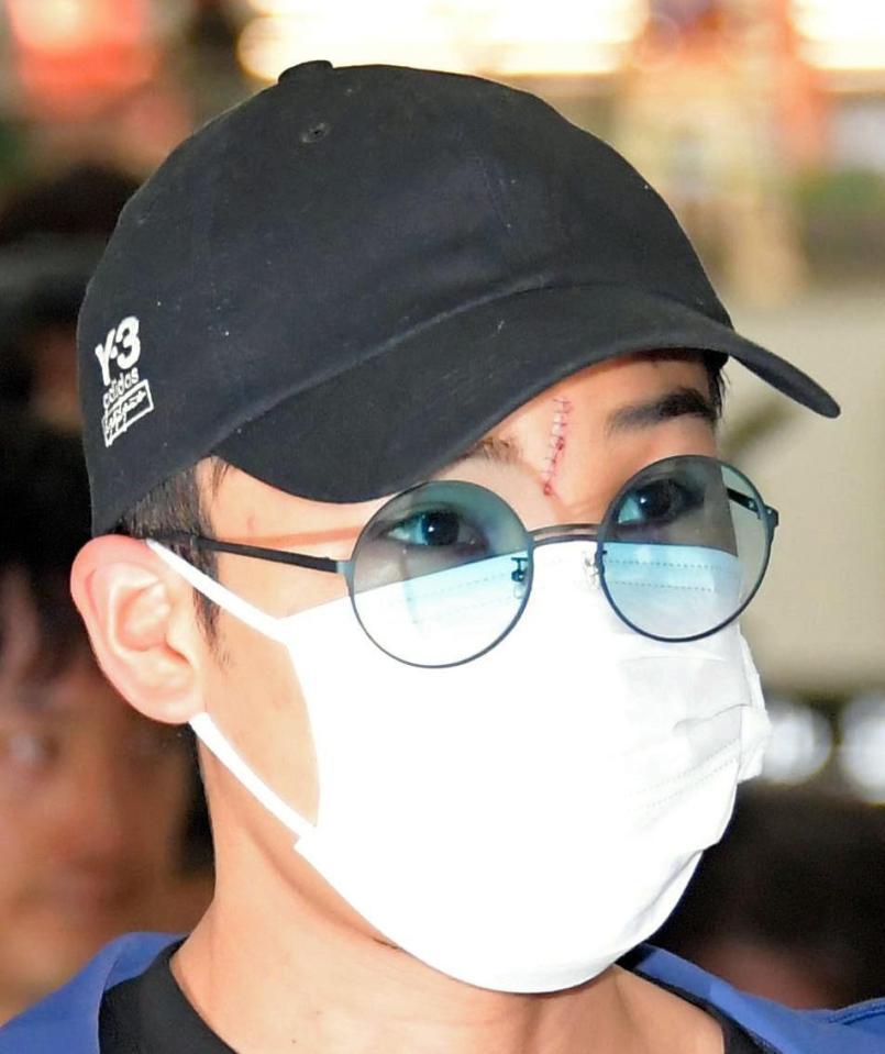 マレーシアから帰国した桃田賢斗の眉間には傷が残っている＝成田空港