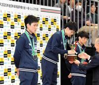 　優勝カップを手渡される宇田幸矢（中央）の横で、ぼう然と一点を見つめる張本智和（左）
