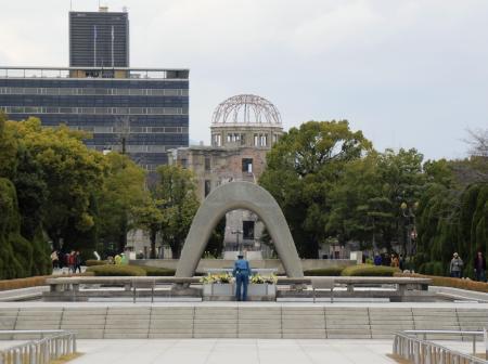 　平和記念公園の原爆死没者慰霊碑。奥は原爆ドーム＝２０１８年１２月、広島市