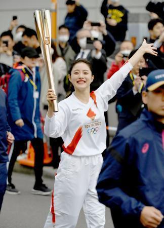 　聖火リレーのリハーサルで、トーチを掲げて走る女優の石原さとみさん＝１５日午前、東京都羽村市