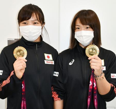 　帰国し、金メダルを手に取材に応じるレスリングの川井梨紗子（右）と妹の友香子＝２３日、成田空港