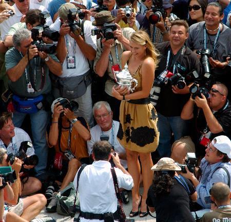 　２００６年の全米オープンで優勝し、トロフィーを手にカメラマンに囲まれるマリア・シャラポワ＝ニューヨーク（ＡＰ＝共同）