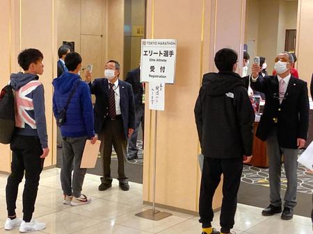 　受け付けで検温する選手たち