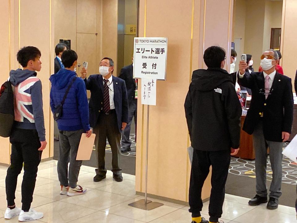 　受け付けで検温する選手たち
