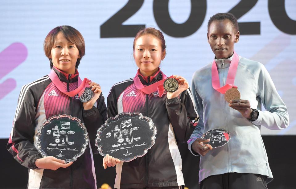 　名古屋ウィメンズマラソン表彰式で記念写真に応じる（左から）２位の安藤友香、１位の一山麻緒、３位のピュアリティー・リオノリポ＝ナゴヤドーム