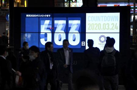　東京五輪開幕までの日数などを伝える大型画面に、重なって表示された数字。新型コロナウイルスの影響で開幕は１年程度延期する方針となった＝東京・新橋駅前
